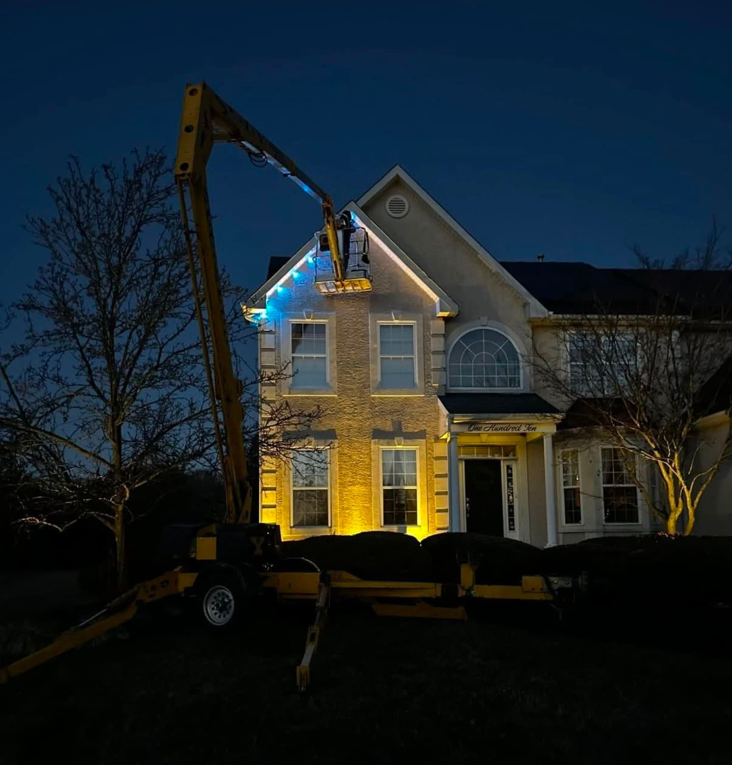 South Jersey home with full permanent holiday lighting installation glowing at dusk
