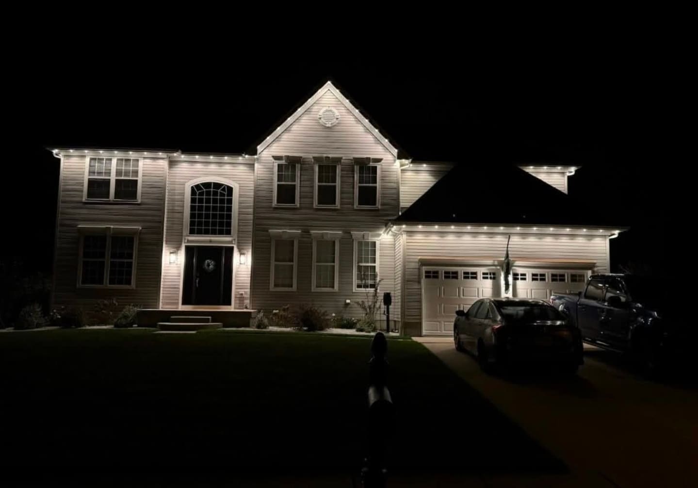 Permanent outdoor lighting glowing along roofline of South Jersey home at night