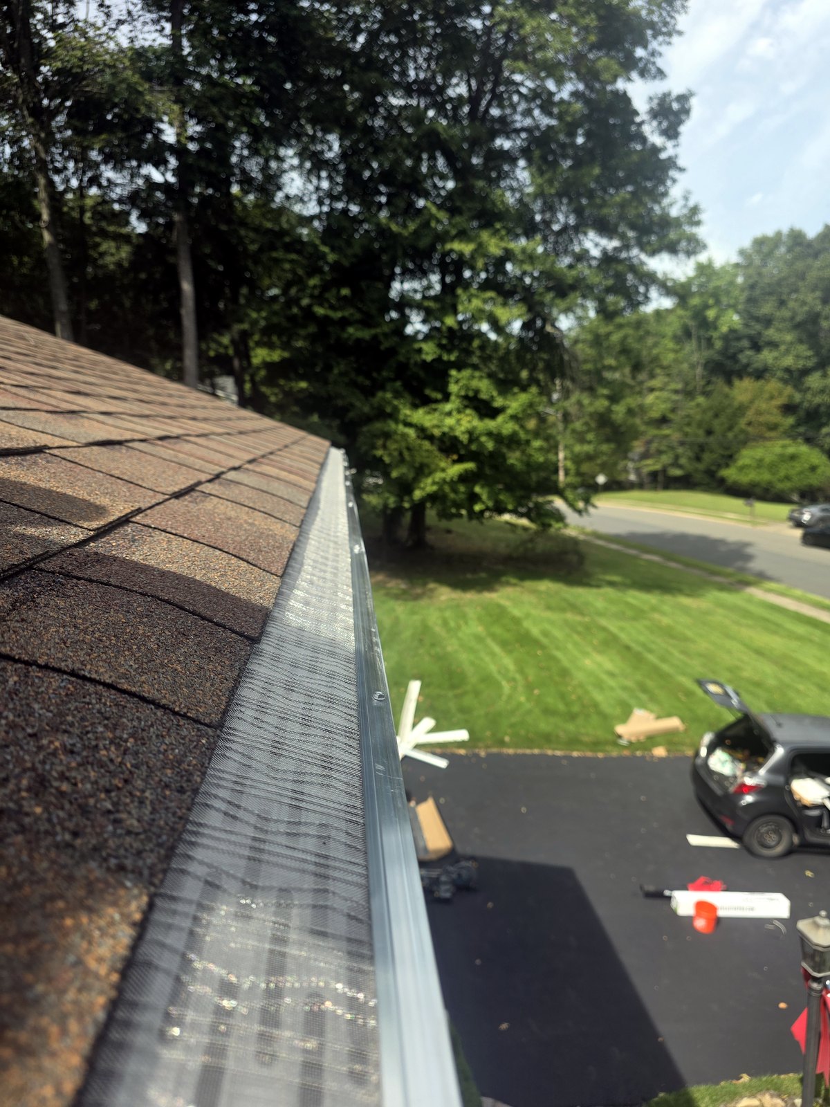 After installation: stainless-steel micro-mesh gutter guard fitted along the same roofline