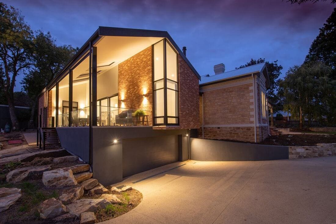 Modern South Jersey home illuminated at dusk with warm interior and doorway lighting
