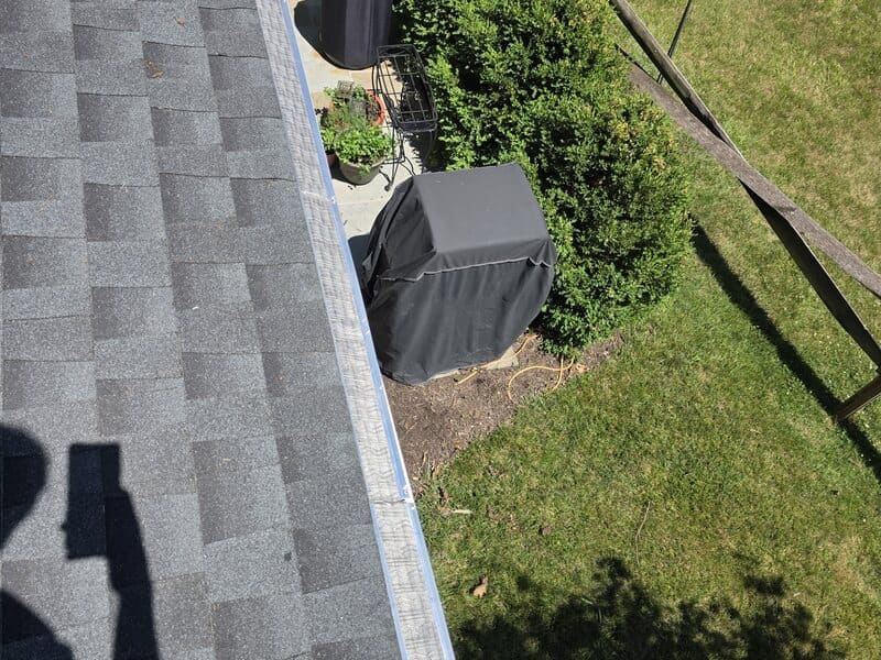 Micro-mesh gutter guard installed edge-to-edge along a South Jersey roofline against the siding